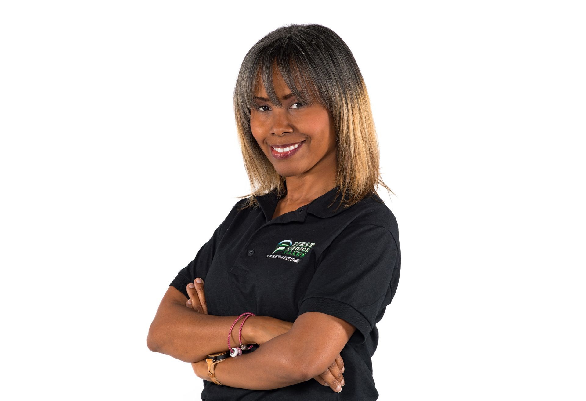 Smiling woman in black polo shirt with crossed arms against white background.